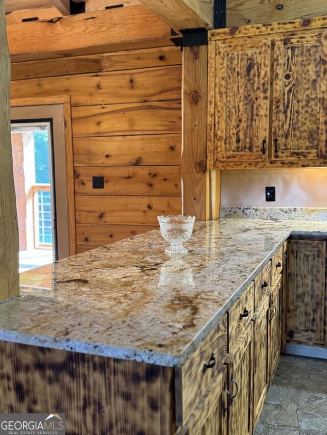 kitchen with light stone countertops and wooden walls