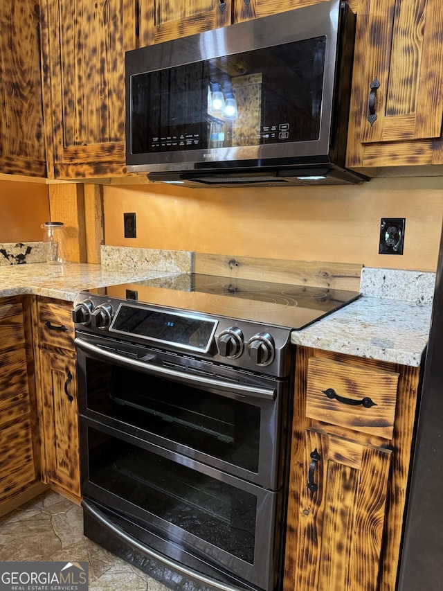 kitchen featuring light stone countertops and stainless steel appliances