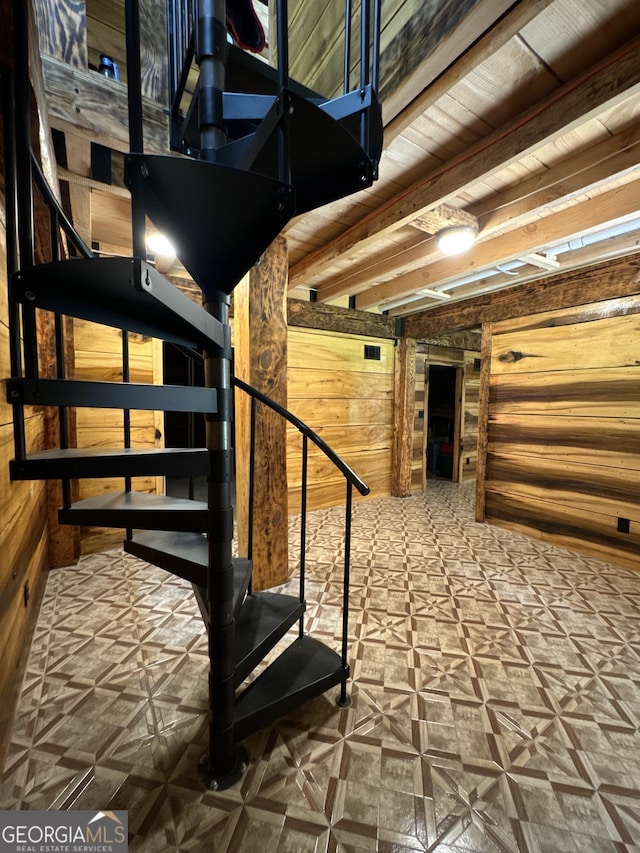 stairs featuring beam ceiling, wooden ceiling, and wood walls