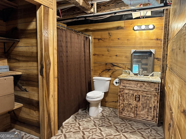 bathroom featuring a shower with shower curtain, vanity, wood walls, and toilet