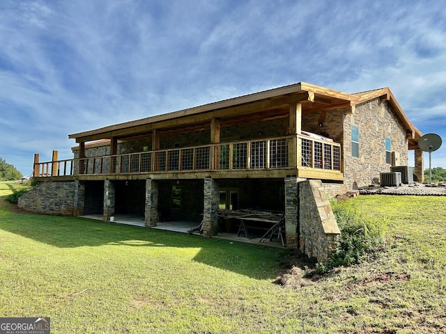 rear view of property with a lawn, central AC, a wooden deck, and a patio