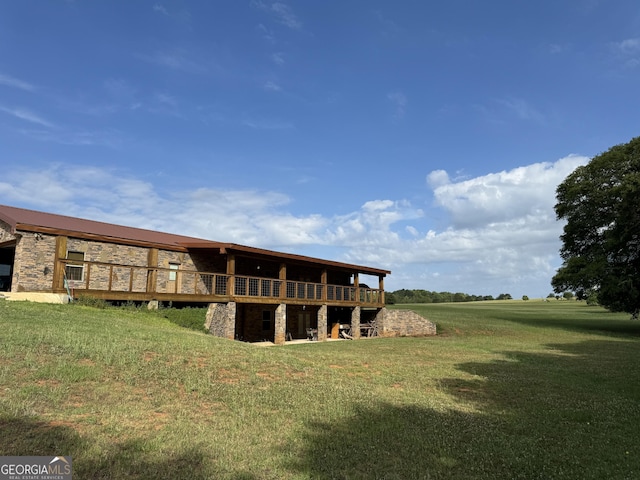 rear view of property featuring a lawn and a deck