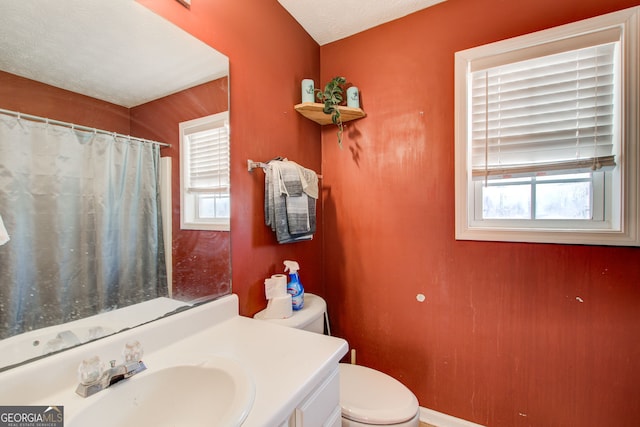 bathroom featuring vanity, a textured ceiling, and toilet