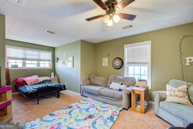 carpeted living room with ceiling fan and a textured ceiling