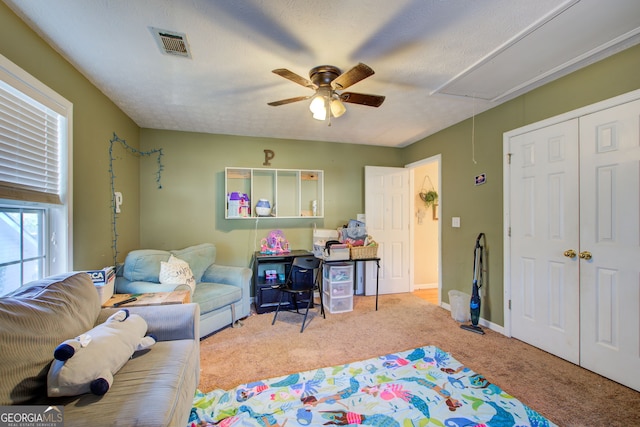 playroom with a textured ceiling, ceiling fan, and light carpet