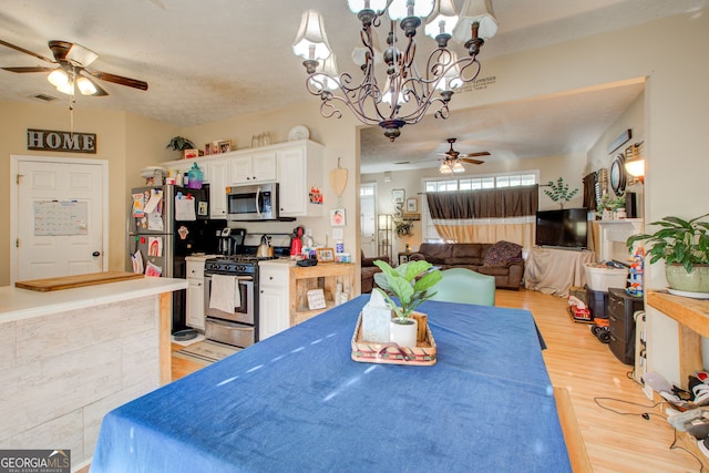 dining space with a textured ceiling, light hardwood / wood-style flooring, and ceiling fan with notable chandelier