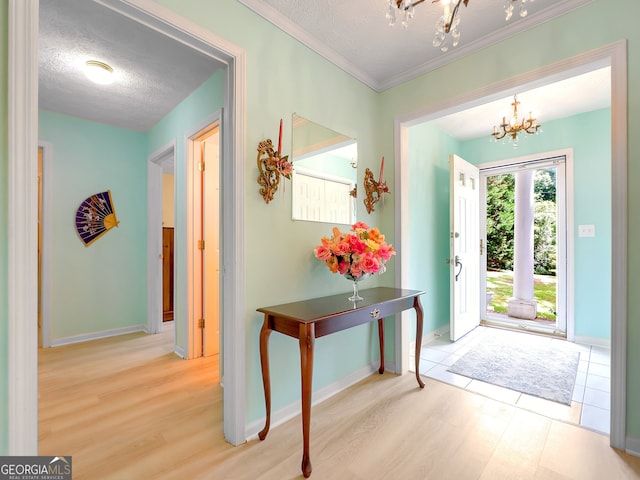 interior space featuring a textured ceiling, crown molding, hardwood / wood-style floors, and a chandelier