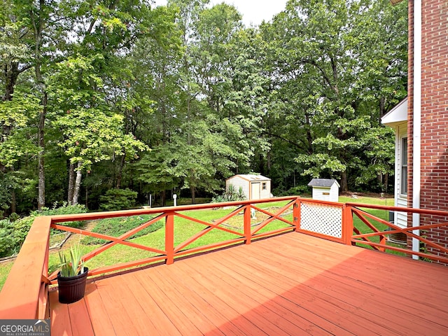 wooden terrace featuring a lawn and a storage shed