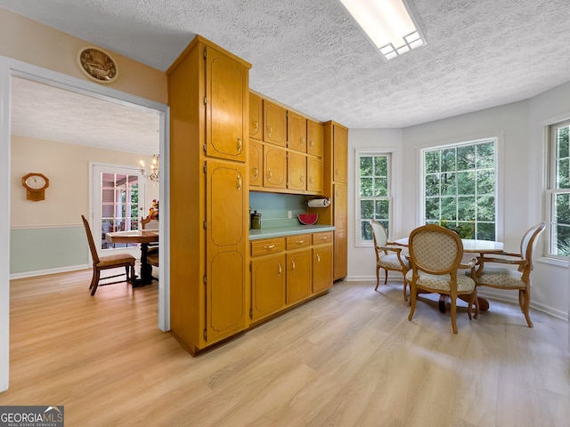 kitchen featuring a textured ceiling, light wood-type flooring, and a chandelier