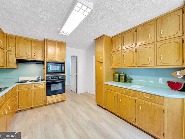 kitchen with light hardwood / wood-style floors, black appliances, and a textured ceiling