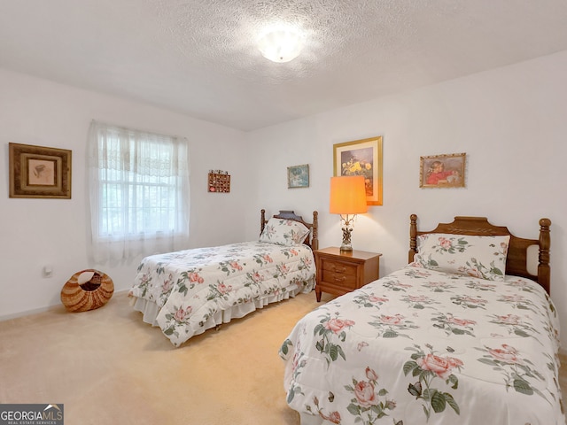 bedroom featuring light colored carpet and a textured ceiling