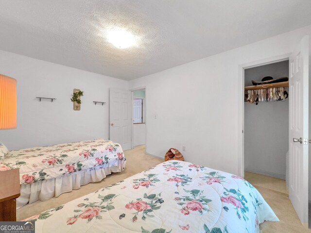 carpeted bedroom featuring a closet and a textured ceiling