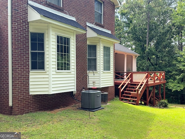 exterior space with a deck, a yard, and central AC unit