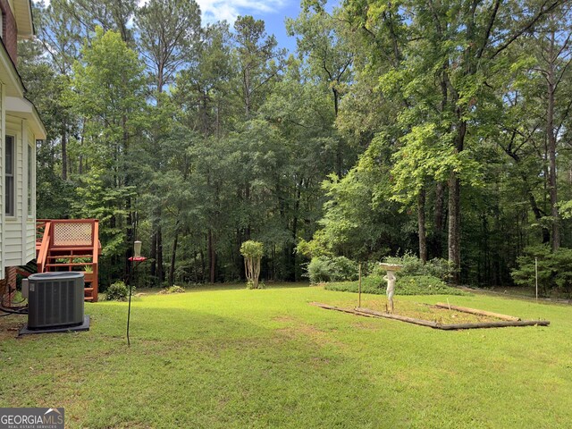 view of yard featuring a wooden deck and central AC