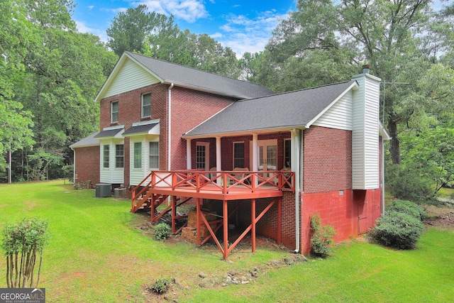 rear view of property featuring a lawn and cooling unit