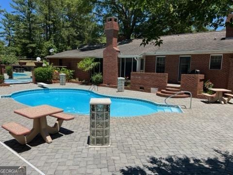 view of pool featuring a patio and a diving board