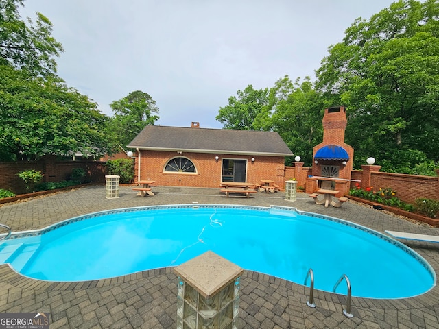 view of pool with a patio and a diving board