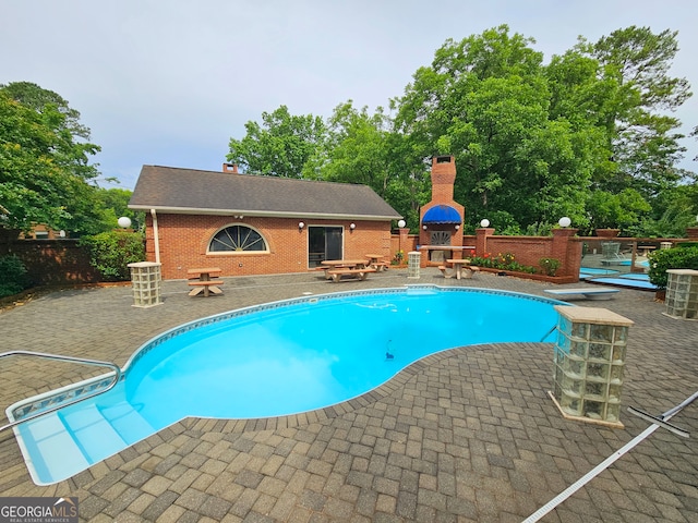 view of pool featuring a patio and a diving board