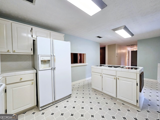 kitchen featuring light tile floors, white cabinetry, tile counters, and white refrigerator with ice dispenser