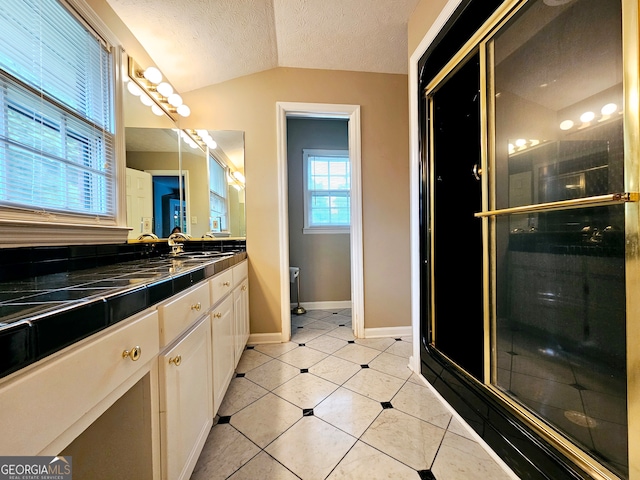 bathroom with an enclosed shower, a textured ceiling, tile floors, lofted ceiling, and large vanity