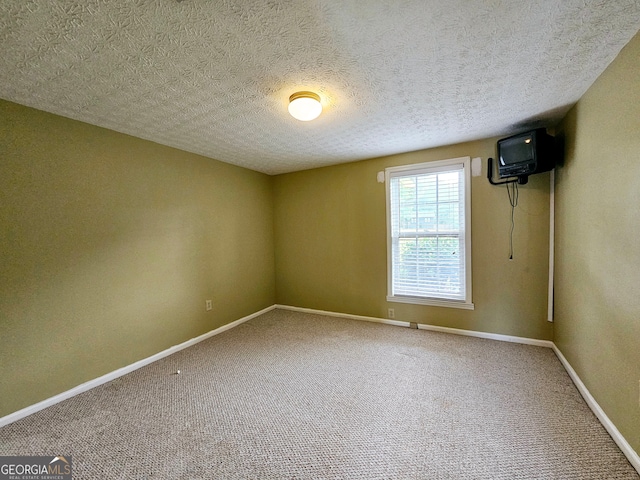 empty room featuring a textured ceiling and carpet flooring