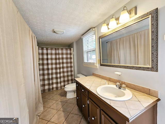 bathroom featuring tile floors, a textured ceiling, toilet, and vanity with extensive cabinet space