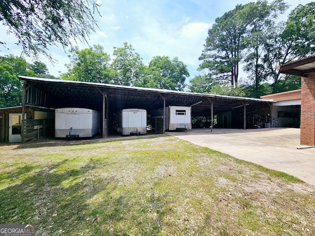 view of vehicle parking featuring a lawn and a carport