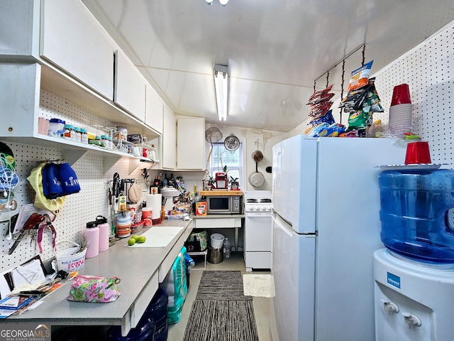 kitchen featuring white cabinets and white appliances