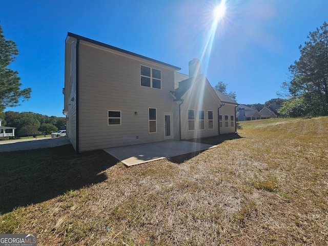 rear view of property featuring a patio and a lawn