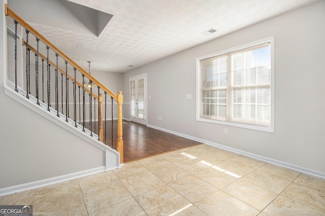 entrance foyer with tile patterned flooring and a textured ceiling