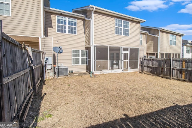 rear view of property with a yard, central AC unit, and a sunroom