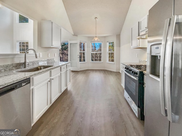 kitchen featuring sink, white cabinets, stainless steel appliances, and vaulted ceiling