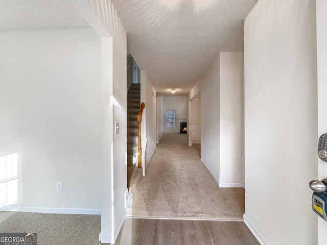 hallway featuring a textured ceiling and light wood-type flooring