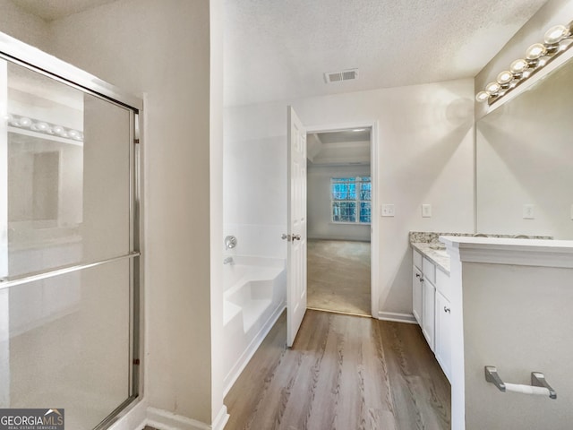 bathroom featuring hardwood / wood-style floors, vanity, a textured ceiling, and independent shower and bath