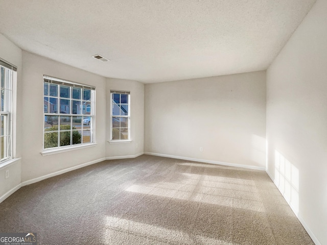 spare room featuring a textured ceiling and carpet floors