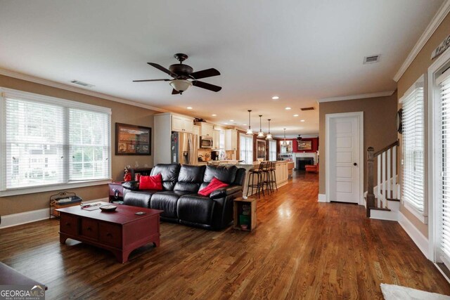 living room featuring ornamental molding, dark hardwood / wood-style floors, and ceiling fan