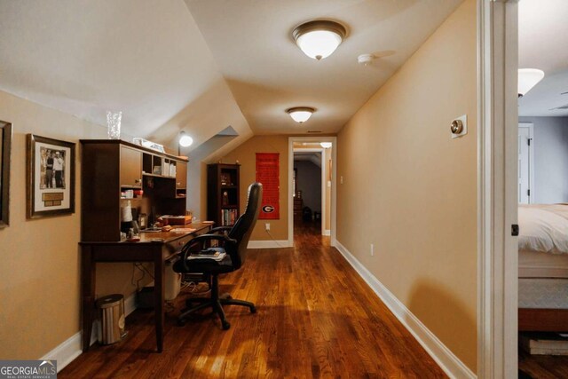 home office featuring dark wood-type flooring and vaulted ceiling