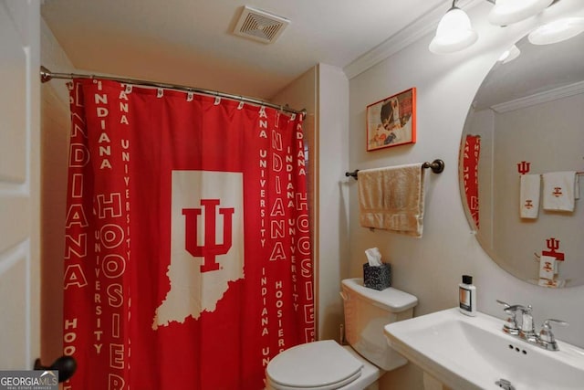 bathroom featuring sink, crown molding, toilet, and walk in shower