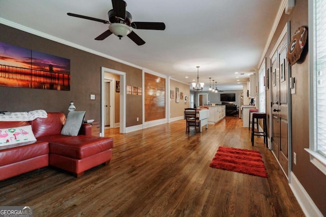 living room featuring wood-type flooring, ceiling fan with notable chandelier, and crown molding