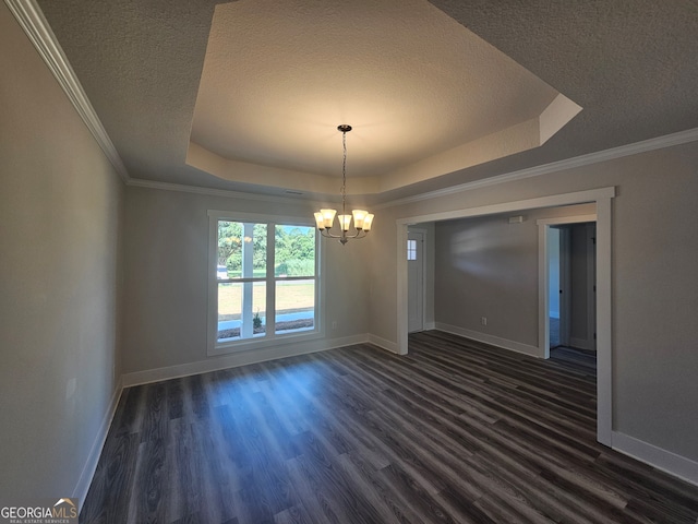 spare room featuring hardwood / wood-style flooring, a tray ceiling, and a chandelier