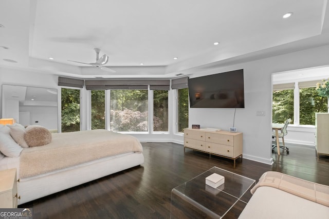 bedroom with ceiling fan, a raised ceiling, and dark hardwood / wood-style flooring