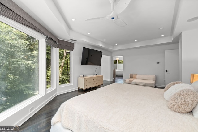 bedroom featuring dark hardwood / wood-style floors, ceiling fan, and a raised ceiling