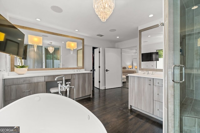 bathroom with a chandelier, hardwood / wood-style flooring, plus walk in shower, and vanity