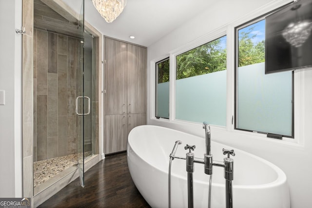 bathroom featuring hardwood / wood-style flooring and plus walk in shower