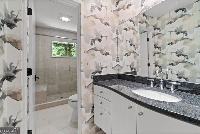 bathroom featuring tile floors, walk in shower, vanity with extensive cabinet space, and toilet