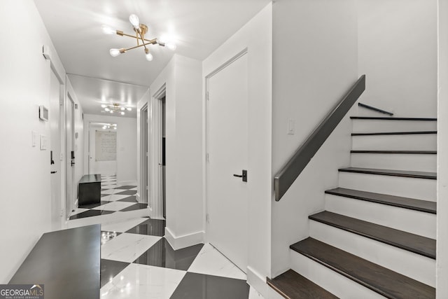 stairway with tile flooring and a chandelier