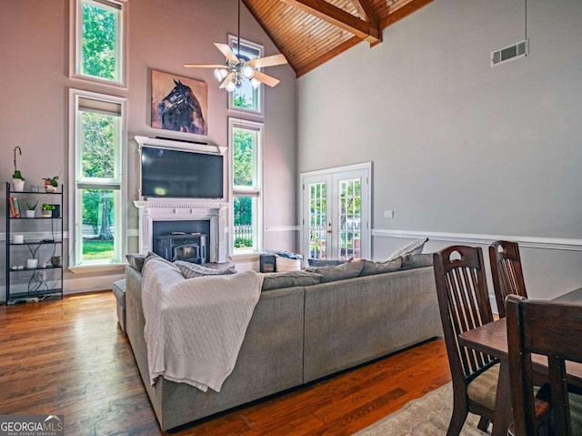 living room featuring beam ceiling, high vaulted ceiling, a healthy amount of sunlight, and hardwood / wood-style flooring