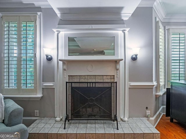 living room featuring wood-type flooring, crown molding, and a tiled fireplace