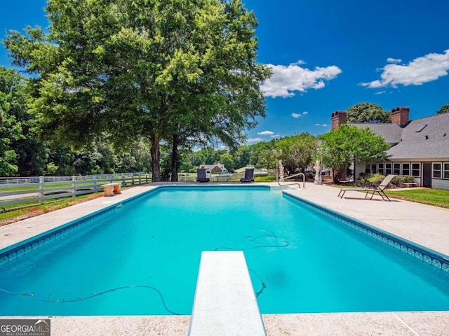 view of pool featuring a patio area and a diving board