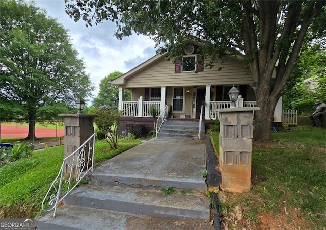 bungalow featuring a porch and a front lawn